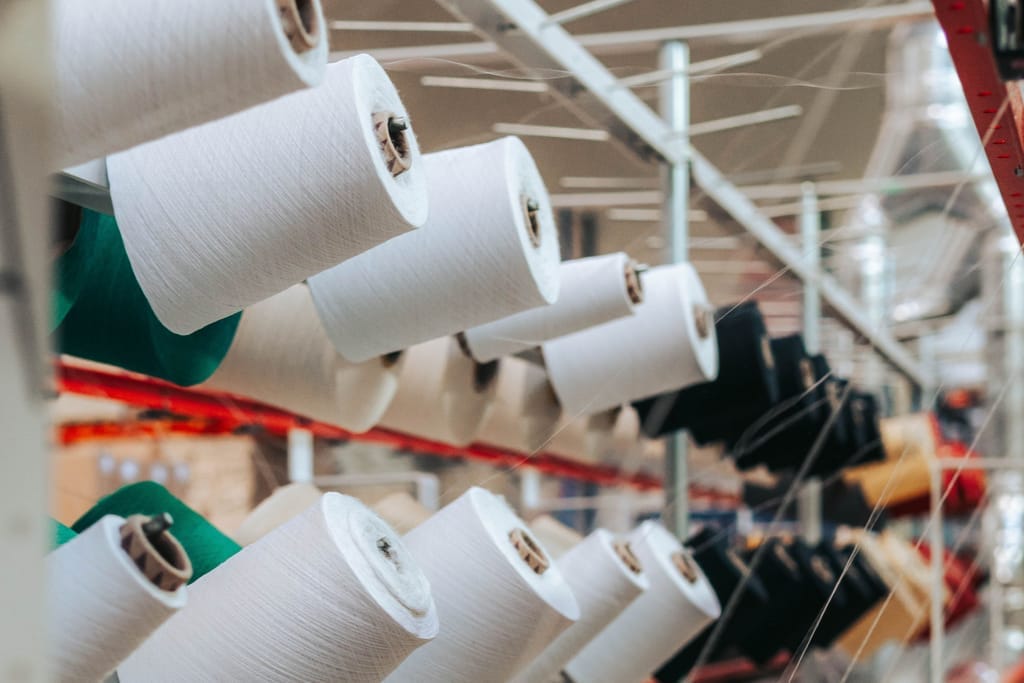 Rows of yarn cones on a textile spinning line (representative)