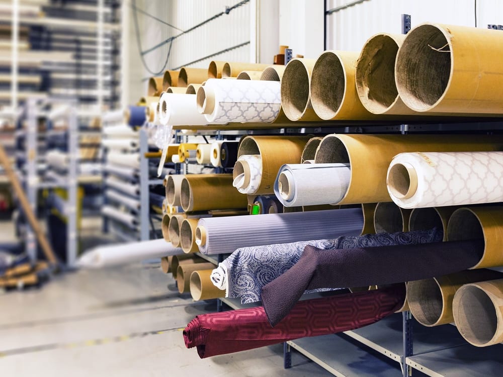 Organised textile rolls in warehouse storage for corporate sourcing coordination